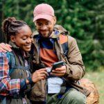 Zwei Wanderer mit Smartphone, Klapp Pavillon im Hintergrund für Pausen im Freien