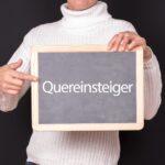 Person hält Tafel mit Quereinsteiger-Schriftzug | Taxifahrer Jobs